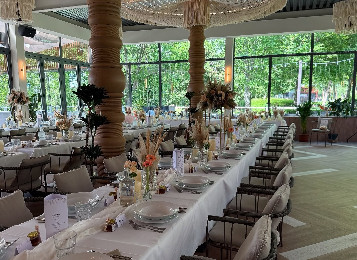 Hosszú, fehér terítős ünnepi asztal szárazvirág-dekorációval a Le Bistro új tetős teraszán