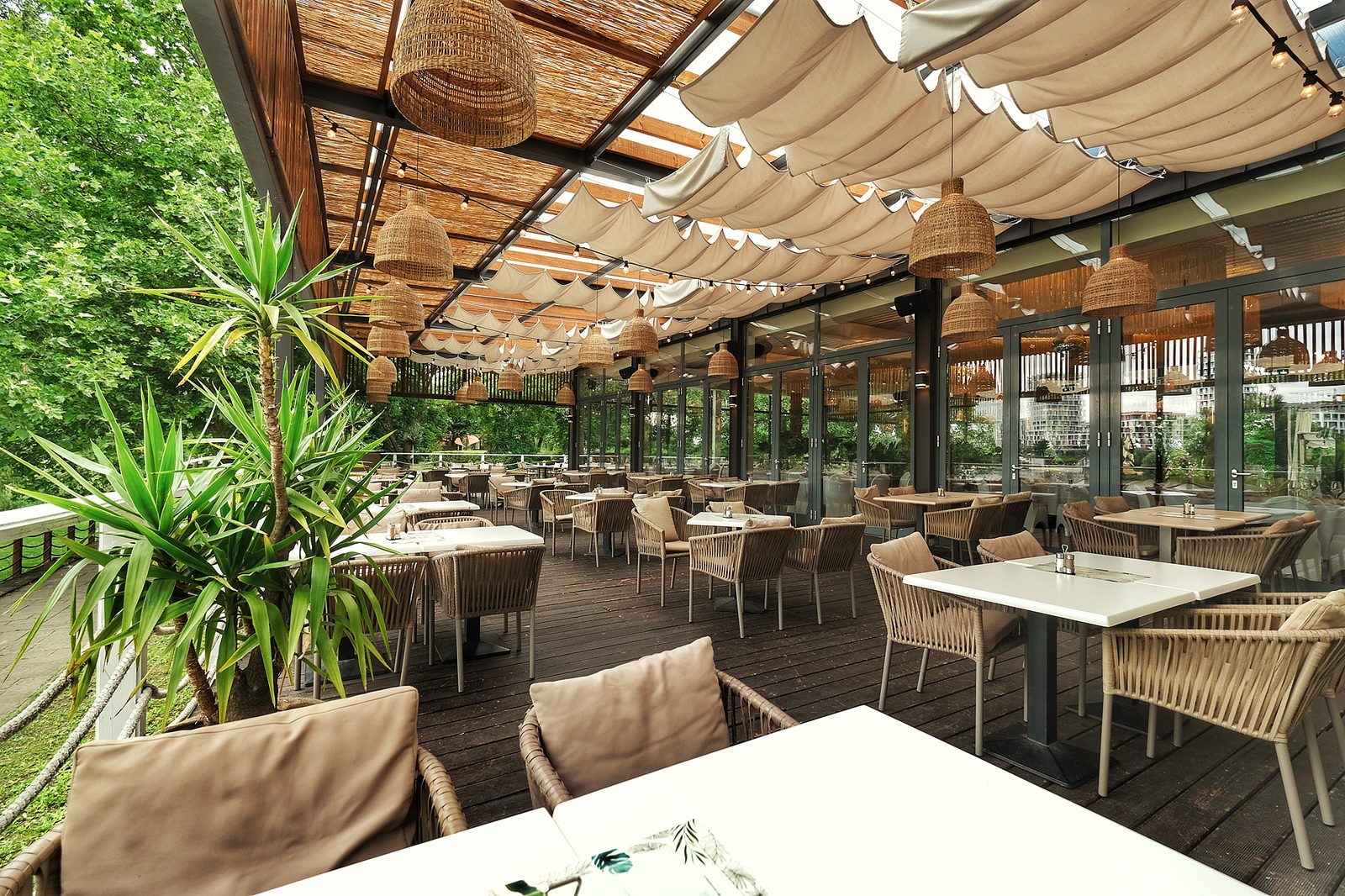 A Le Bistro fedett terasza, háttérben a budapesti skyline az üvegfalon át